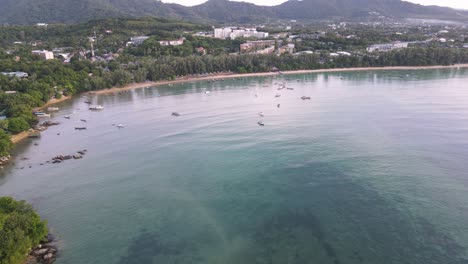 Drone-aerial-slow-pan-down-to-tropical-blue-water-to-Thai-boats