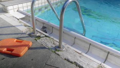 water splashes over the side of an outdoor pool.