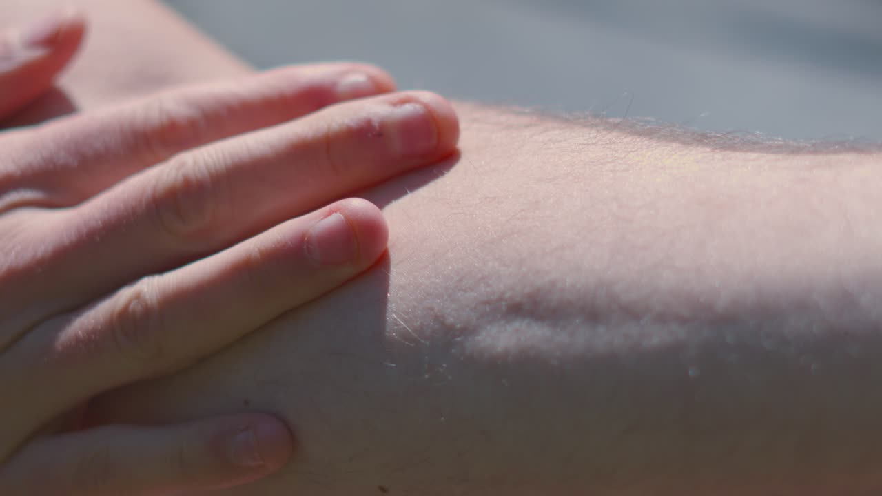 Hand Rubbing Up and Down Arm Applying Sunscreen on Bright Sunny Day to Protect from Harmful UV Rays and Avoid Sunburn. Dermatology Prevention Summer Footage.