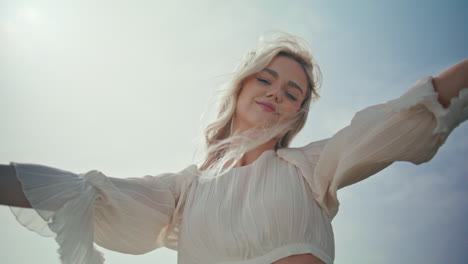chica romántica disfruta del viento de pie la luz del sol de cerca. mujer levantando las manos al cielo.