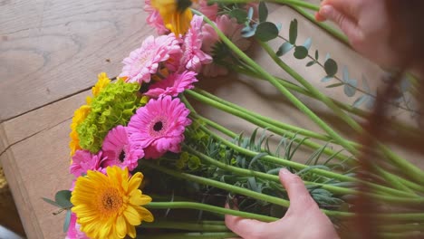 flower arrangement of gerbera transvaal daisies close up from the florist over shoulder view in slow motion 4k