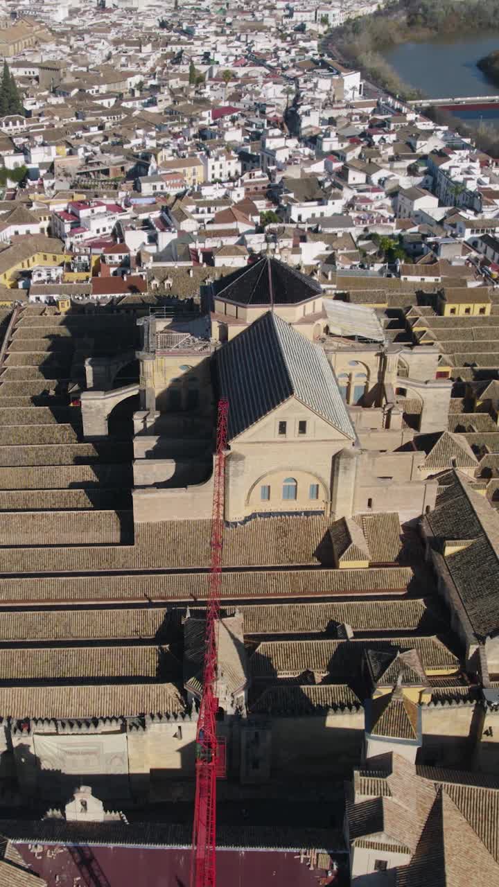 Ripresa aerea verticale della Cattedrale-Moschea di Cordoba, che mostra l'ambientazione fluviale e i tetti del centro storico UNESCO.