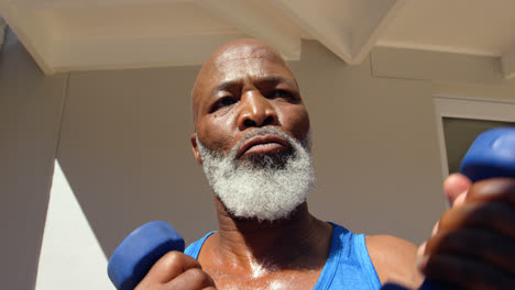 Low-angle-view-of-determined-mature-black-man-exercising-in-backyard-of-home-4k