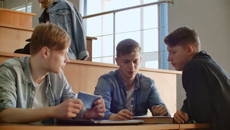 The-group-of-cheerful-happy-students-sitting-in-a-lecture-hall-before-lesson.-The-group-of-cheerful-students-sitting-in-a-lecture-hall-before-lesson.