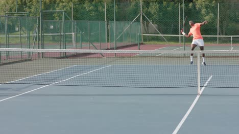 Afroamerikanischer-Männlicher-Tennisspieler,-Der-Dem-Gegner-Auf-Dem-Außenplatz-In-Zeitlupe-Den-Ball-Serviert