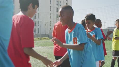 niños de fútbol estrechándose las manos en un día soleado