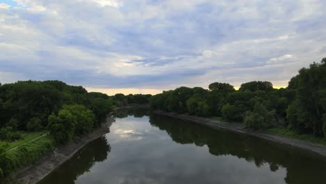 a stroll down a river that feeds the mississippi on the southern side of the twin cities in minnesota follows a bike trail with bikers riding on the bottom left side