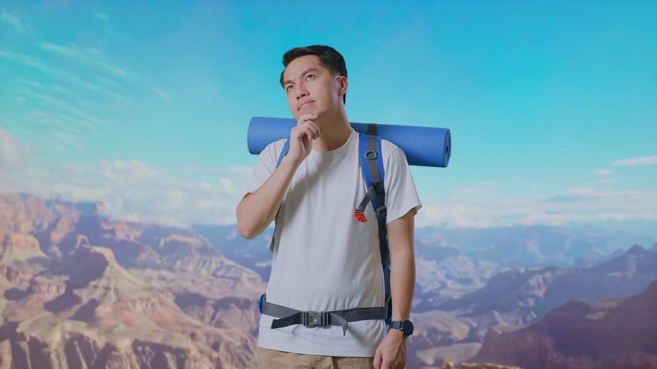 Asian Male Hiker With Mountaineering Backpack Thinking About Something And Looking Around While Traveling At The Top Of Mountain