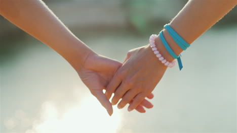 two woman tenderly hold hands romantic couple