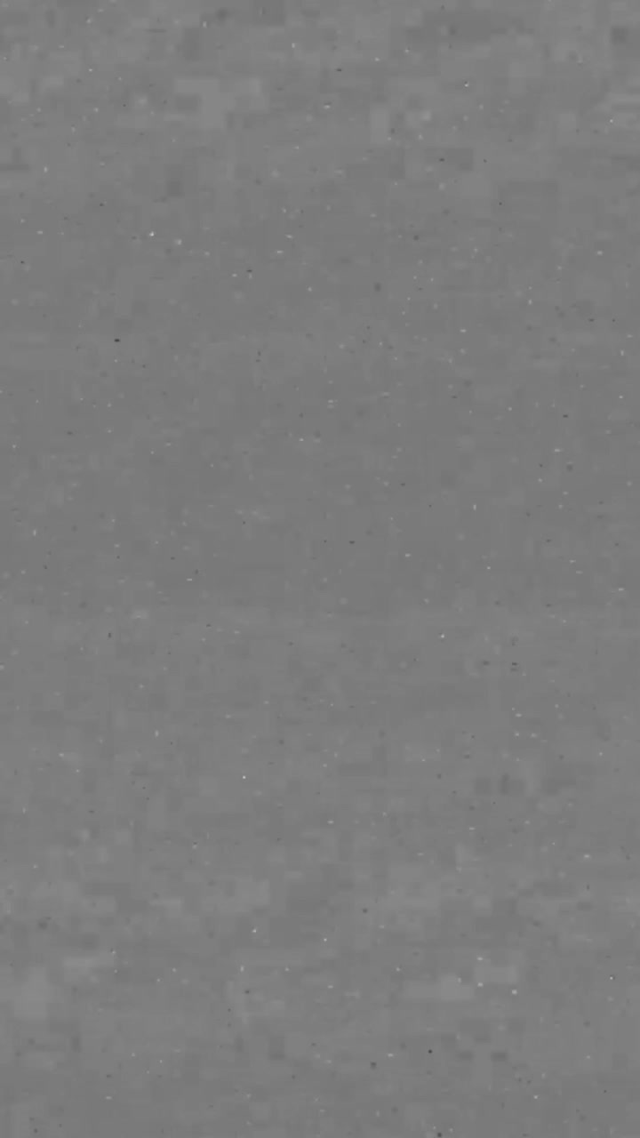 Verticaal grijs scherm met subtiele filmkorrel en stofdeeltjes, dat een oude, versleten vintage filmtextuur of -ruis simuleert