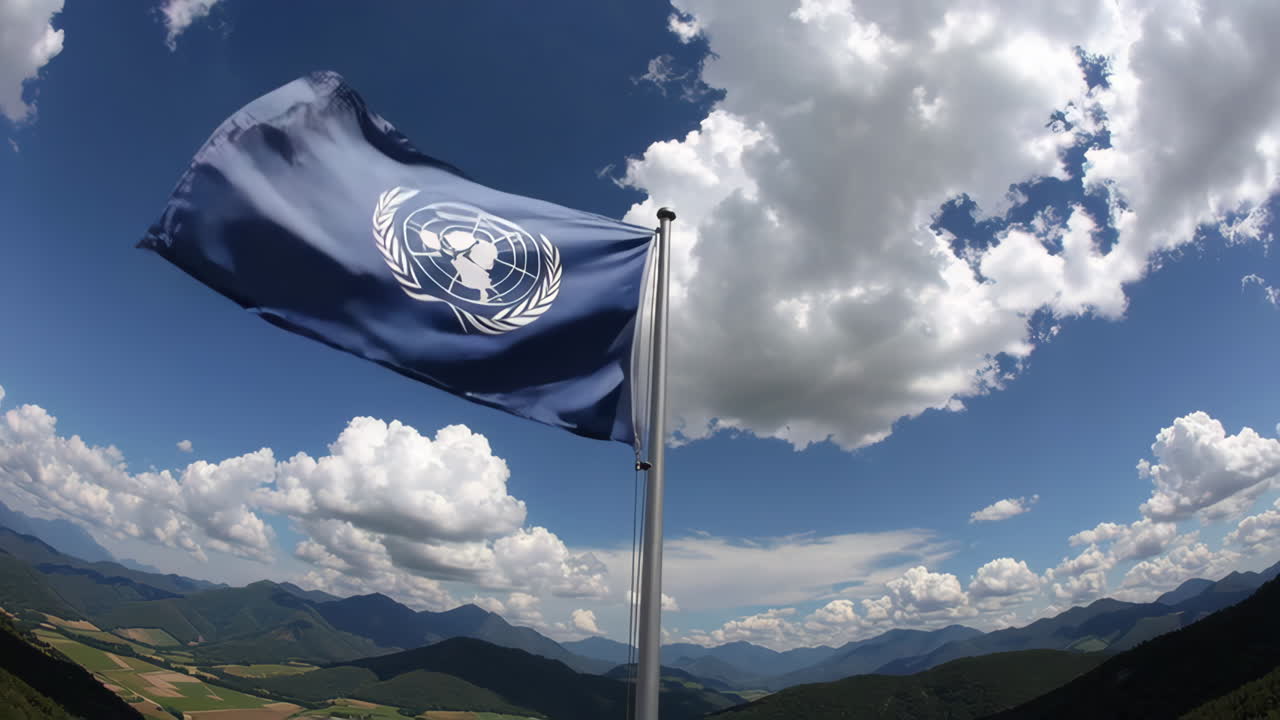 United Nations Flag Waving Over Mountain Landscape
