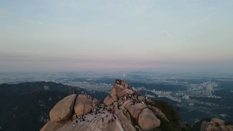 Tourists-climb-Bukhansan-mountain-with-a-beautiful-sunset-view-of-Seoul