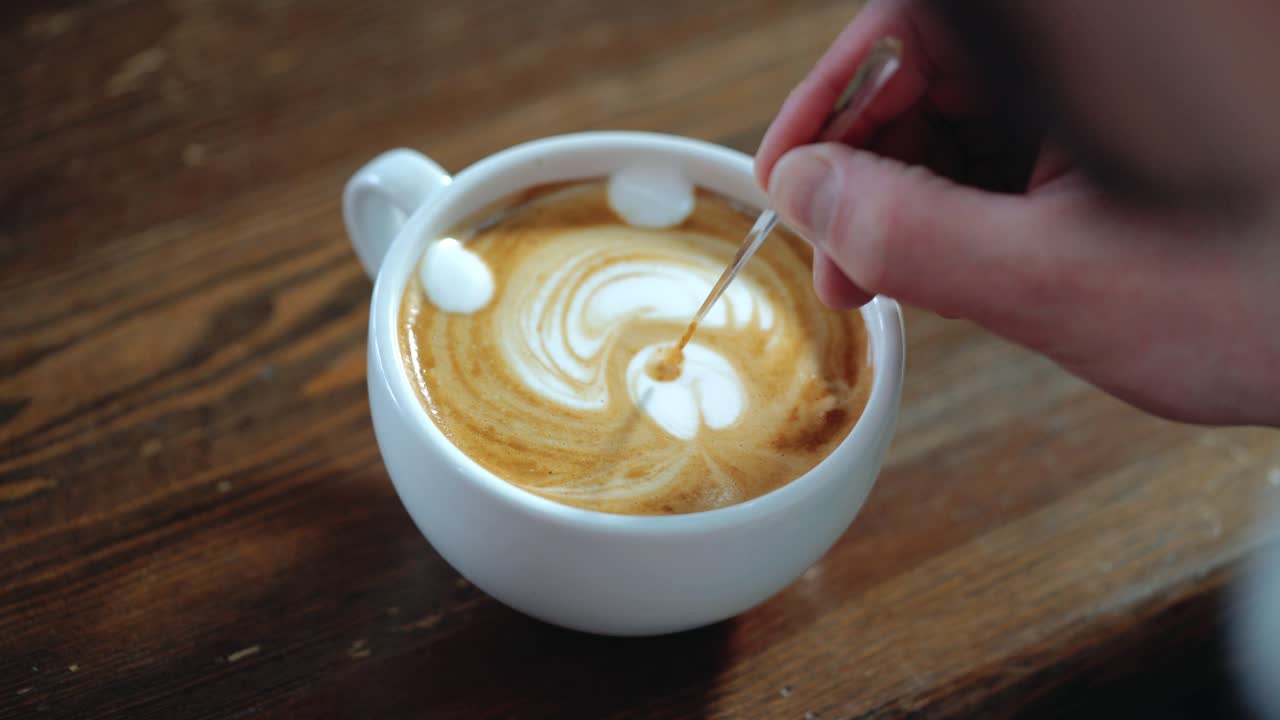Barista makes a drawing on coffee. Art of making cappuccino in a cup.