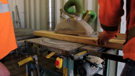 man is cutting wood with a machine