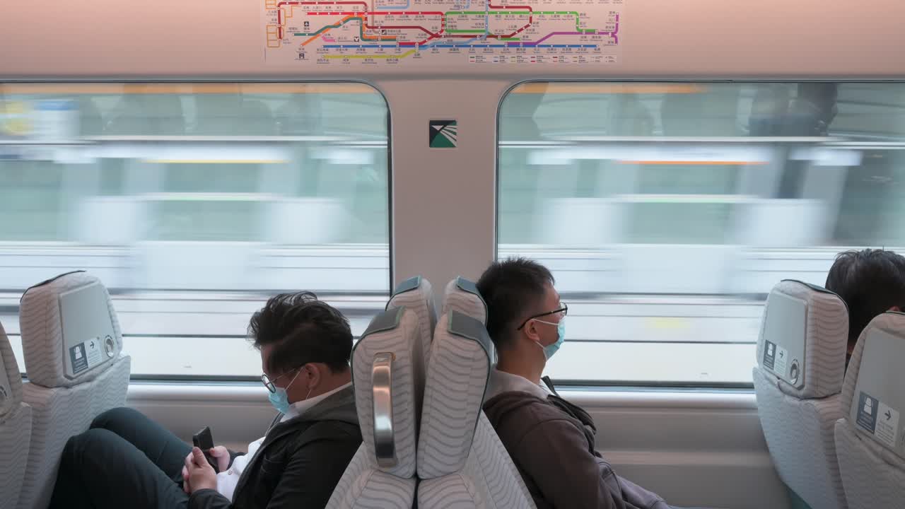 중국 승객들이 홍콩 국제공항으로 향하는 mtr 급행열차에 탑승하면서 앉아 있는 모습이 보인다.