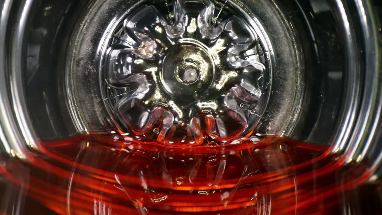 흔들거리며 움직이는 주스 또는 스포츠 음료 병 바닥의 붉은 액체