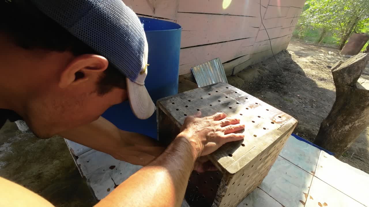 Man pressing on perforated mold to release fresh llanero cheese outdoors
