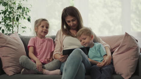 madre cariñosa abraza a los niños viendo dibujos animados divertidos juntos