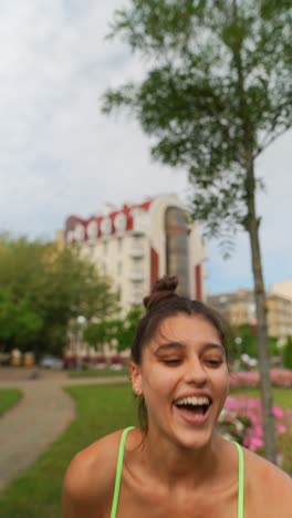 young woman holding a pug in a park