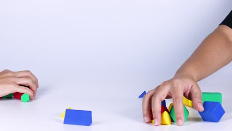 hands organizing colorful geometric shapes on table