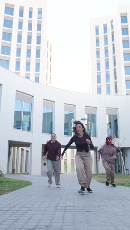 young women dancing outside modern building