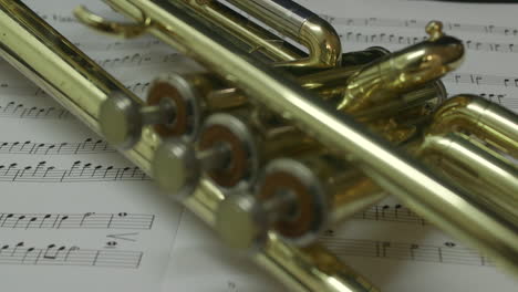 brass trumpet lying on sheet music. slider shot