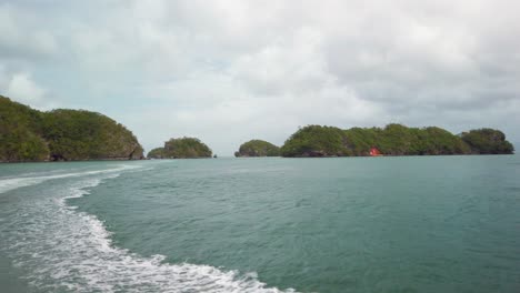 the coast of los haitises national park is dotted with small islets, viewed from a moving boat during a cloudy day. dominican republic