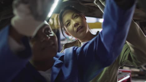 Video-of-two-diverse-female-car-mechanics-repairing-car