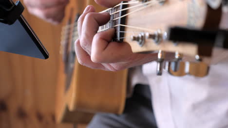 acoustic guitar strummed by musician, slow motion close up