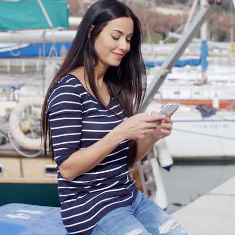 joven de moda relajándose en un puerto marino