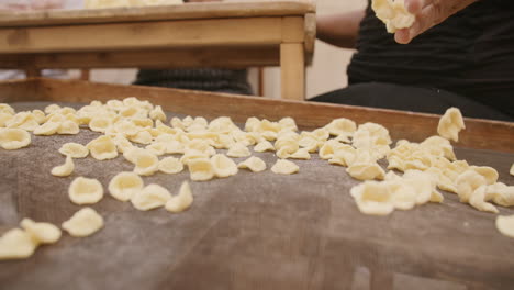 Cerrar-Imágenes-En-Cámara-Lenta-De-Una-Dama-Lanzando-Conchas-De-Conchiglie-Recién-Hechas-En-Una-Red