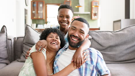 Portrait-of-happy-african-american-mother,-father-and-and-son-embracing-in-living-room,-slow-motion