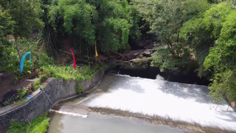 Luftaufnahme:-Luft-Terjun-Bandung,-Flusswasser,-Das-Einen-Alten-Historischen-Damm-In-Einem-Tropischen-Dschungel-Hinunterfließt-Bali,-Ubud-–-Indonesien