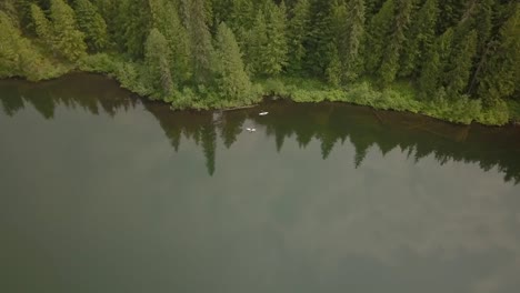 Vista-Aérea-De-Kayakistas-En-Un-Lago-De-Montaña-Remoto