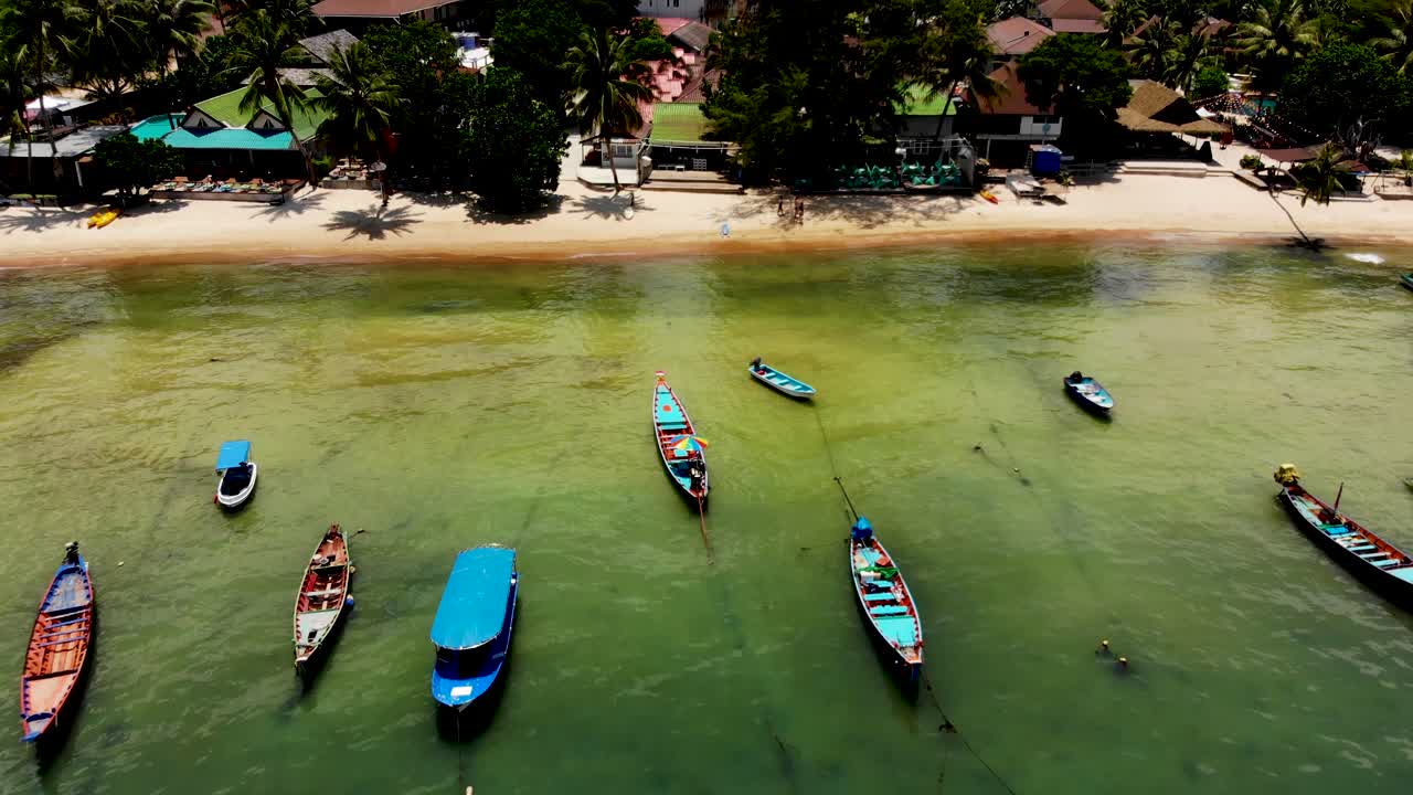 sacando una toma de un dron aéreo para revelar las lanchas de madera y los turistas que están remando en sus kayaks y tablas de remo en la playa de sairee en la isla de koh tao en la provincia de surat thani en tailandia