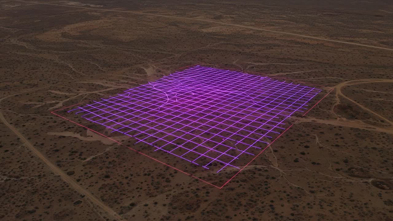 Aerial View of a Geometric Grid Pattern in Vibrant Purple and Pink Over a Sparse Desert Landscape, Showcasing Distinctive Lines and Shapes in the Terrain
