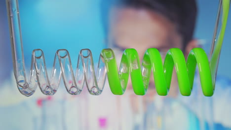 changing the acid color. close up and slow motion of yellow blue green liquid spiraling horizontally right to left in a scientific glass condenser. biofuel processing through a laboratory condenser. high quality 4k footage