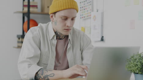 joven trabajando en una computadora portátil en una oficina moderna