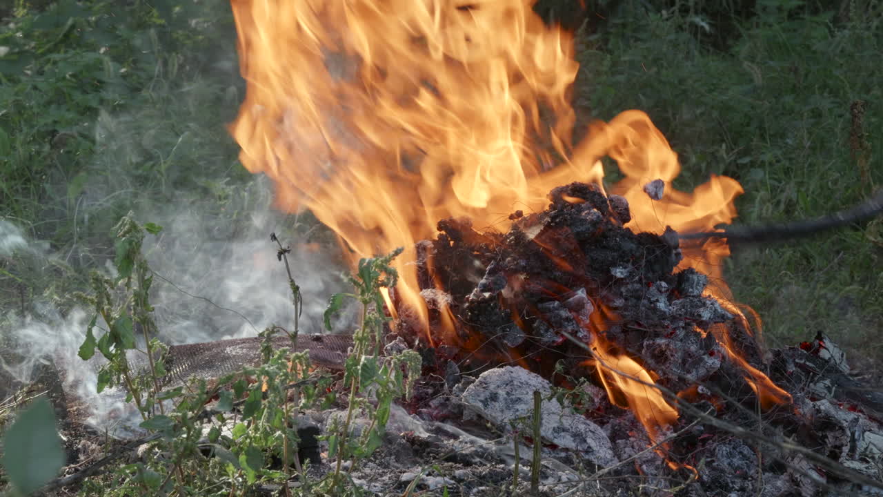 Fire with smoke and pitchfork stirring embers.