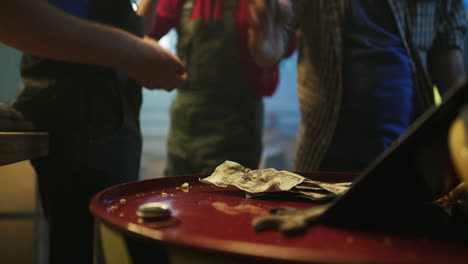 people counting cash on a red barrel
