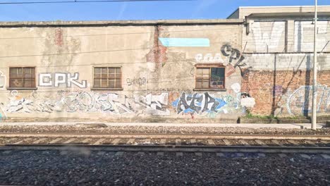 graffiti-covered walls viewed from a moving train