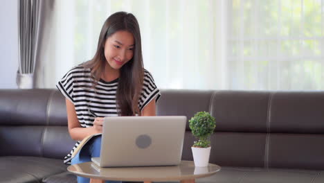Schöne-Asiatische-Frau,-Die-Von-Zu-Hause-Aus-Am-Laptop-Arbeitet