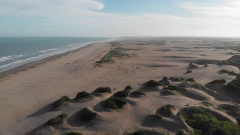 aerial tilt to horizon, carilo sand dune beach on atlantic, argentina