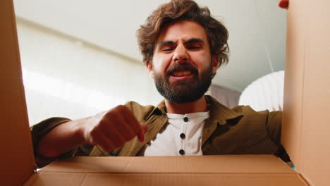 happy arabian man shopper unpacking cardboard box delivery parcel online shopping purchase at home