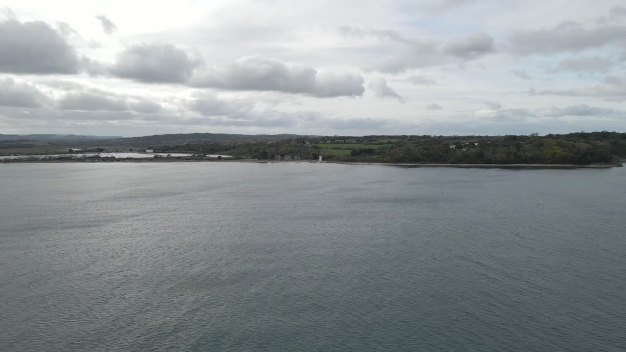 Aerial view of St Helens village named in dedication to St Helena Church, a destroyed church built in the 12th century, Cluniac priory. Only the tower of the church remains, drone going towards beach