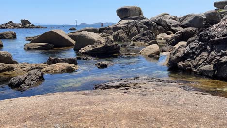 Zeitraffer-Von-Felsen-Am-Ufer-Mit-Wellen-Und-Klarem-Wasser-An-Sonnigen-Tagen