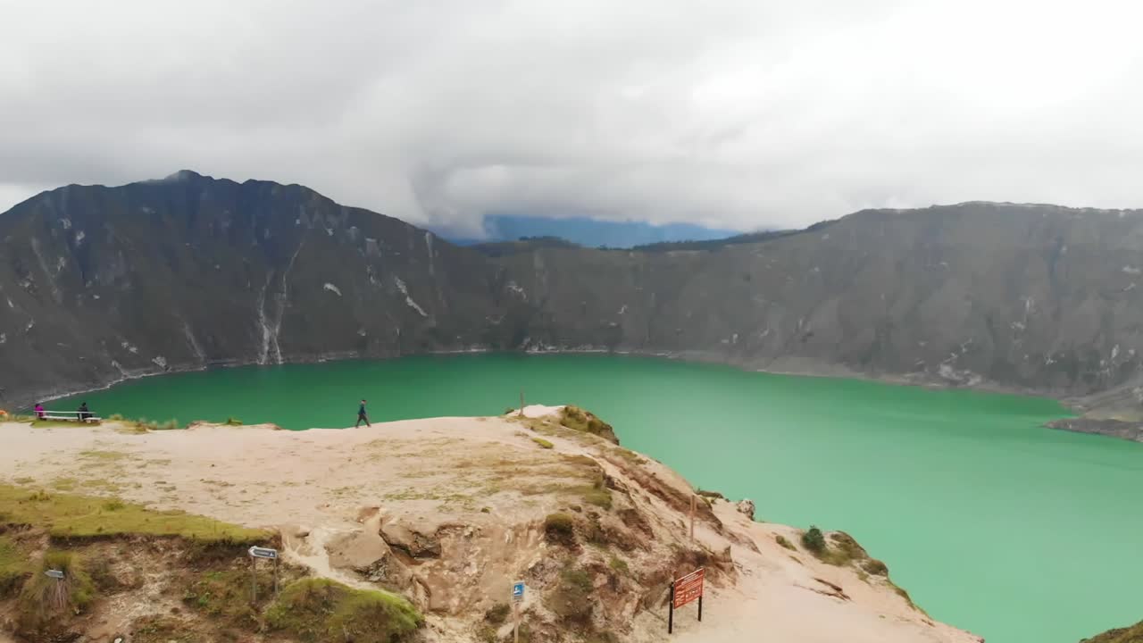 empujón aéreo en una toma de dolly con un punto de vista panorámico con vistas al lago turquesa de quilotoa en ecuador