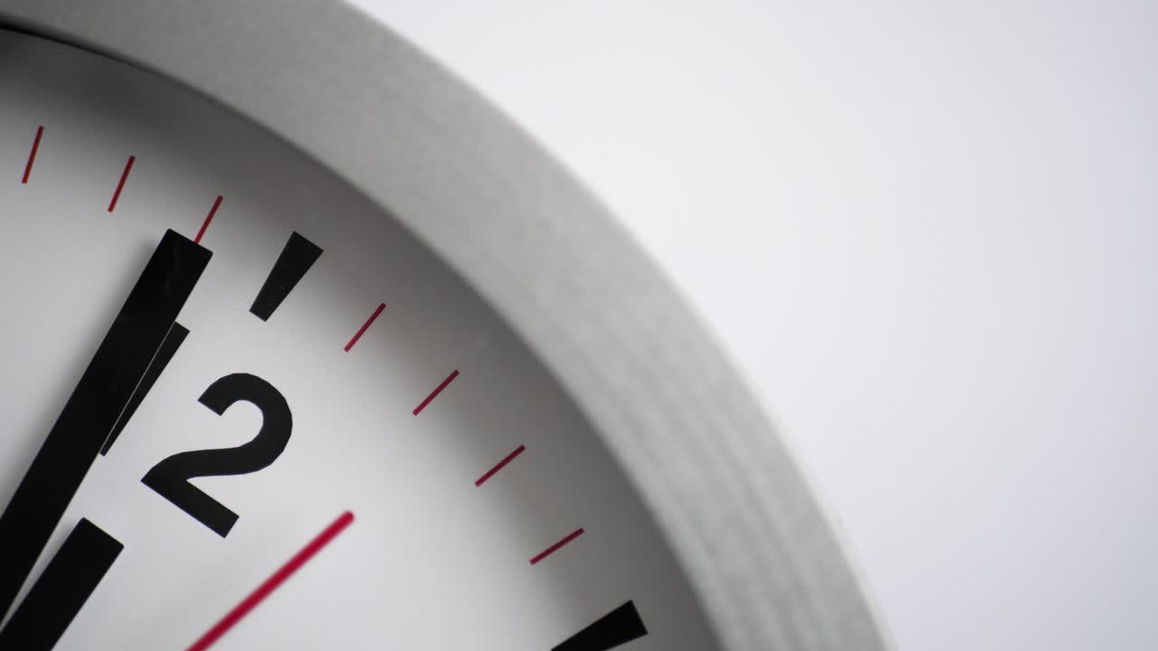 cerca de un reloj blanco en fondo blanco, señalando un minuto a la medianoche