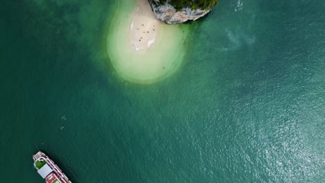 Drone-View-of-Small-Beach-on-Rocky-Carst-Mountain-Island,-Unveiling-Spectacular-Ha-Long-Bay