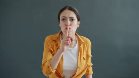 woman gesturing silence and stop